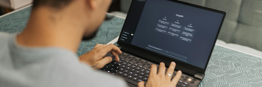 En man sitter vid en laptop med ChatGPT.