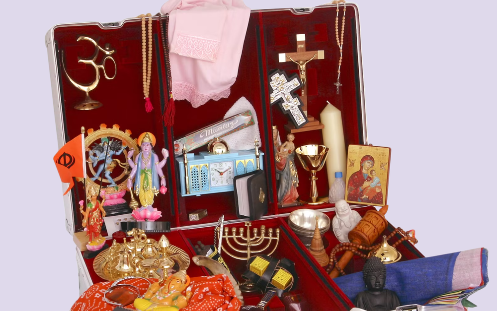 En resväskan fylld med olika religiösa symboler.