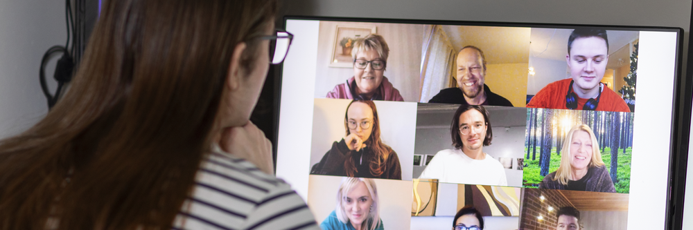 En kvinna sitter framför en datorskärm i ett videomöte.